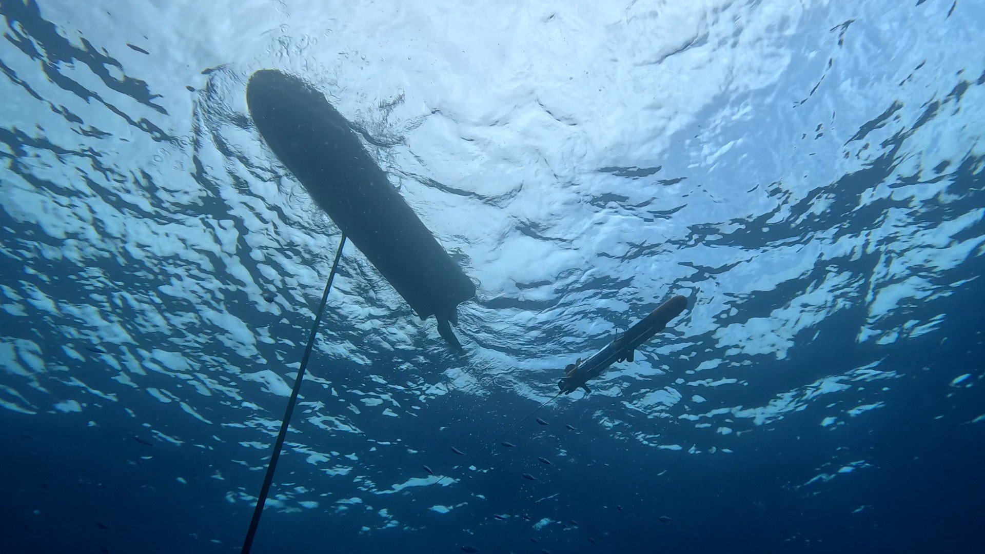 An unmanned surface vehicle and a UUV operating beneath the surface