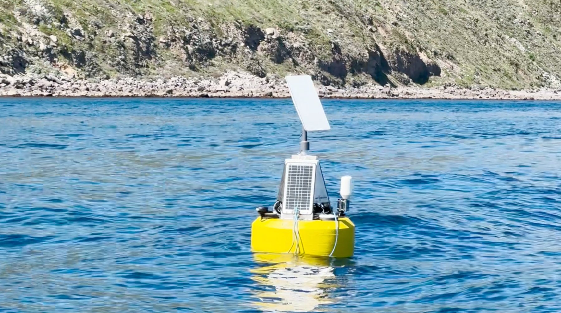 HydroBuoy surface gateway on the water, with solar panel and satellite antenna
